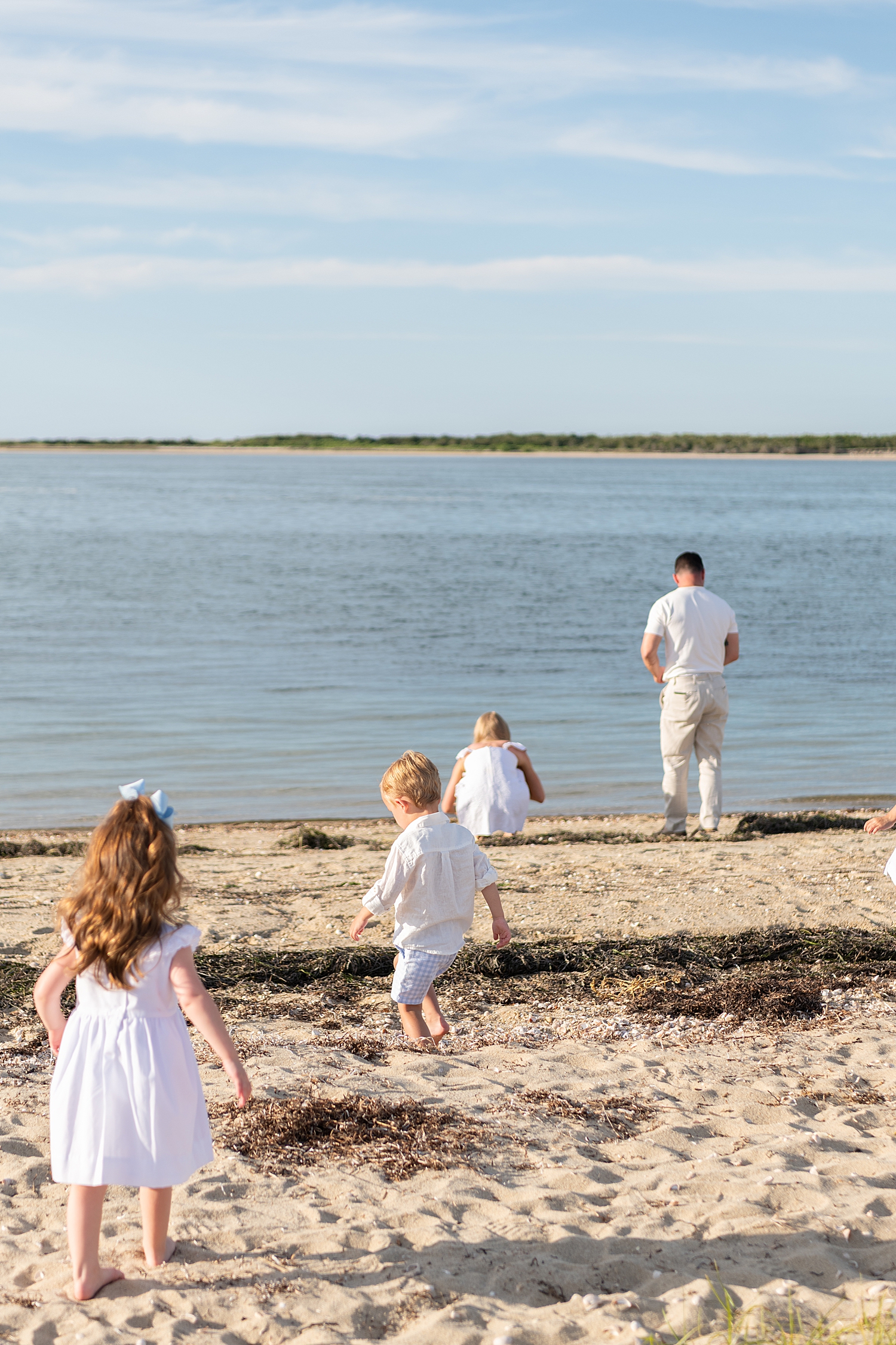 three kids trail behind dad to the water by Massachusetts photographer