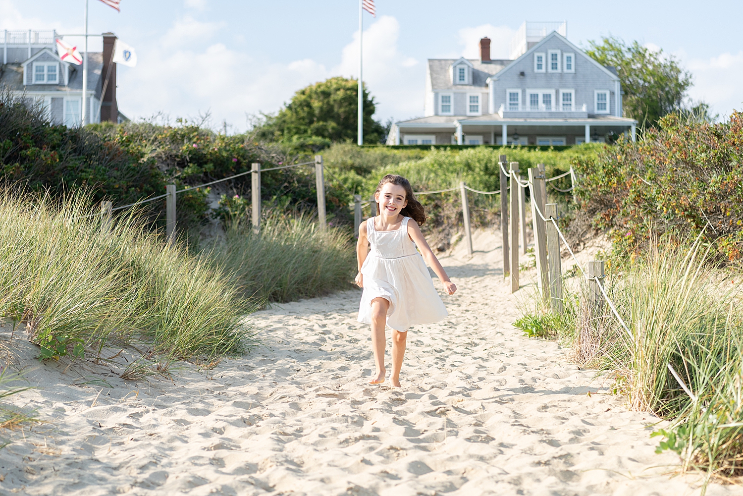 little girl in white dress runs towards water by Rachel Elizabeth Photography