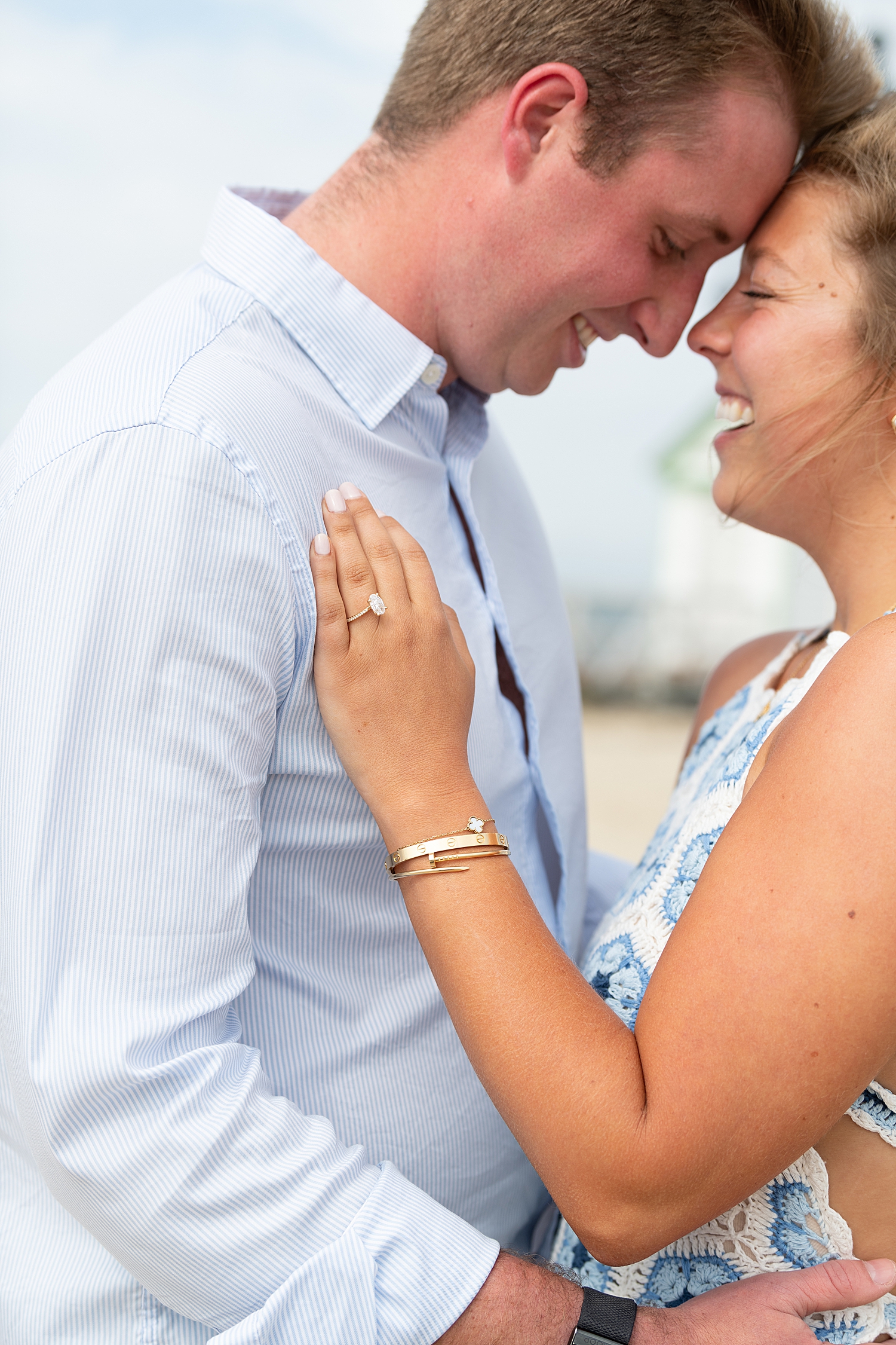 engaged couple embrace after woman said yes for proposal at Brant Point Lighthouse