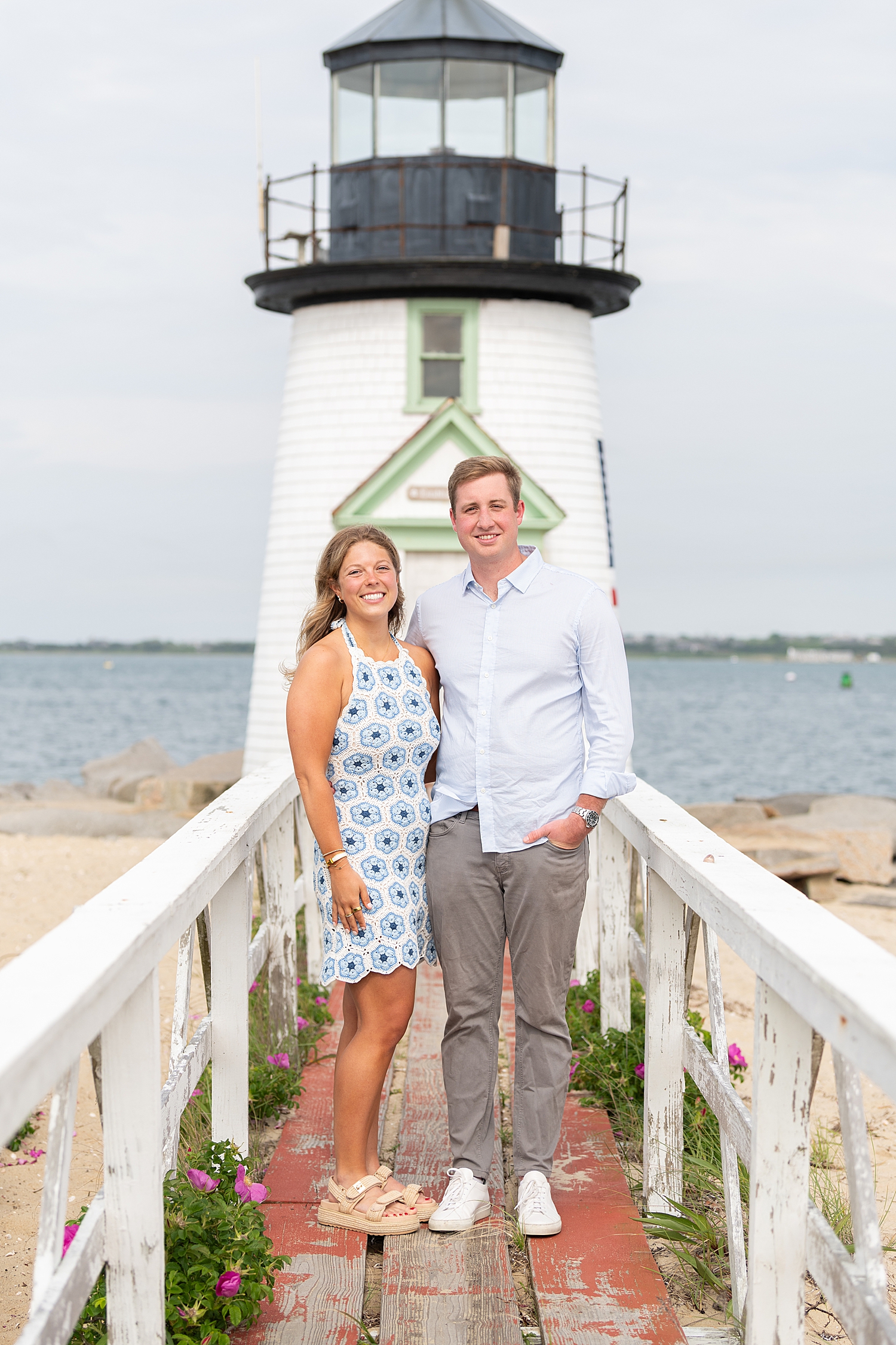 Newly engaged couple stand on dock by Rachel Elizabeth Photography