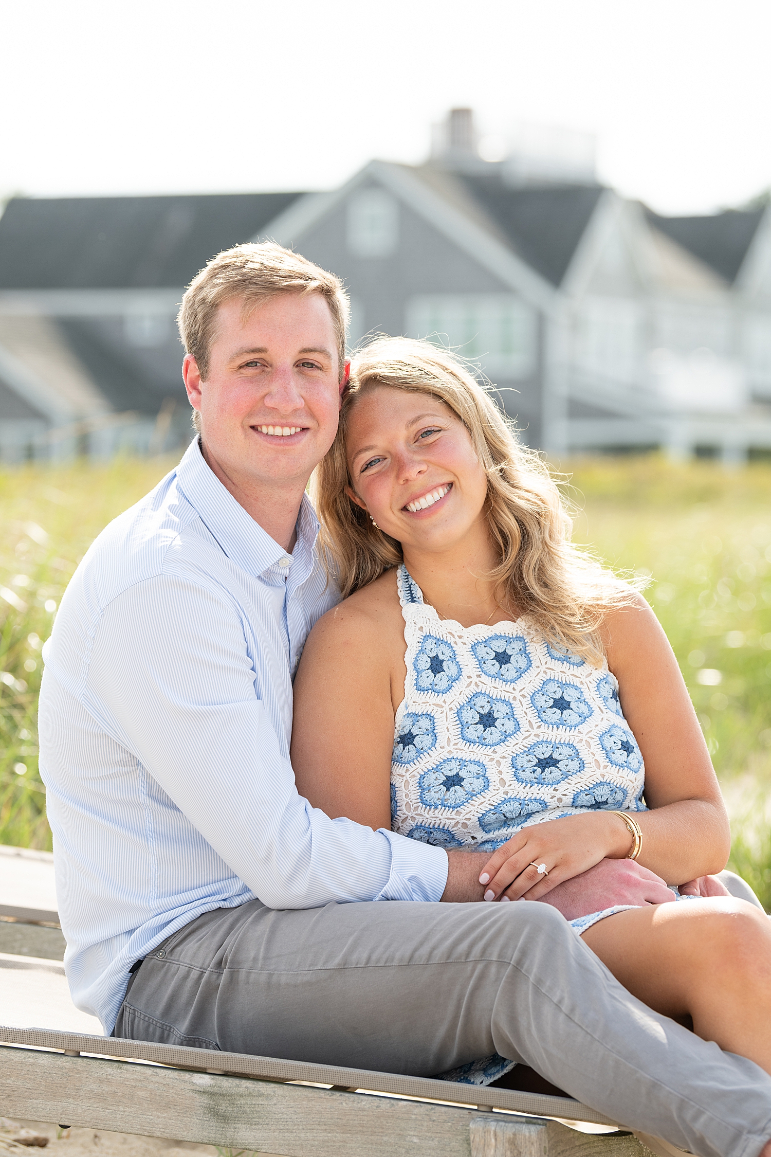 engaged couple sit near the beach by Nantucket family photographer