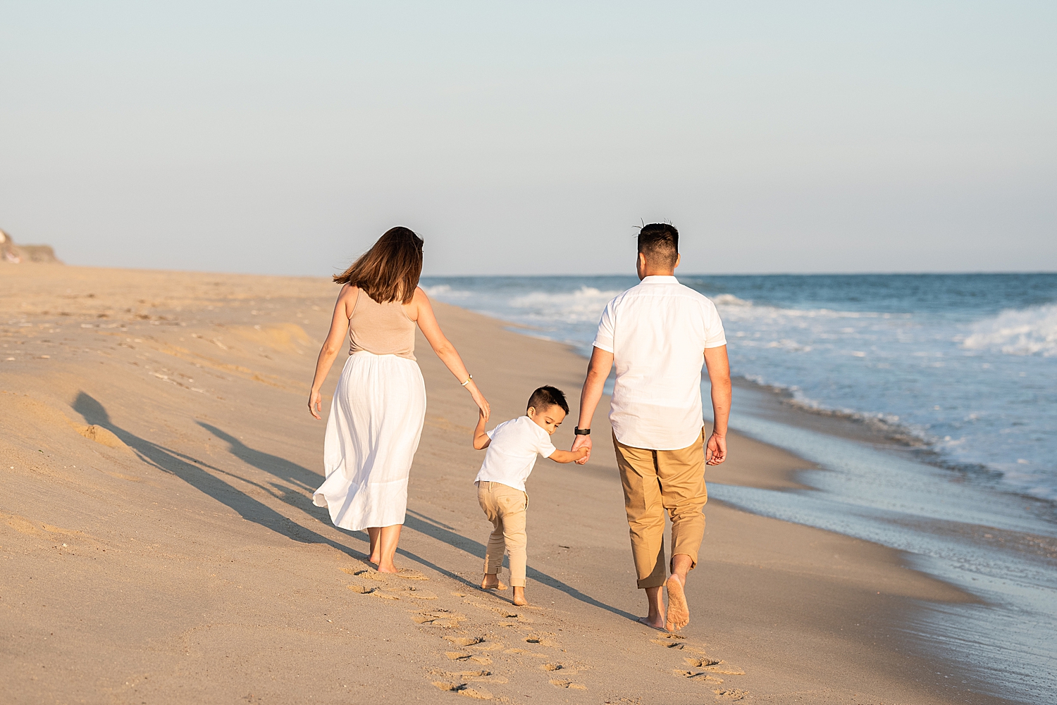 family of three walking near the ocean in Nantucket