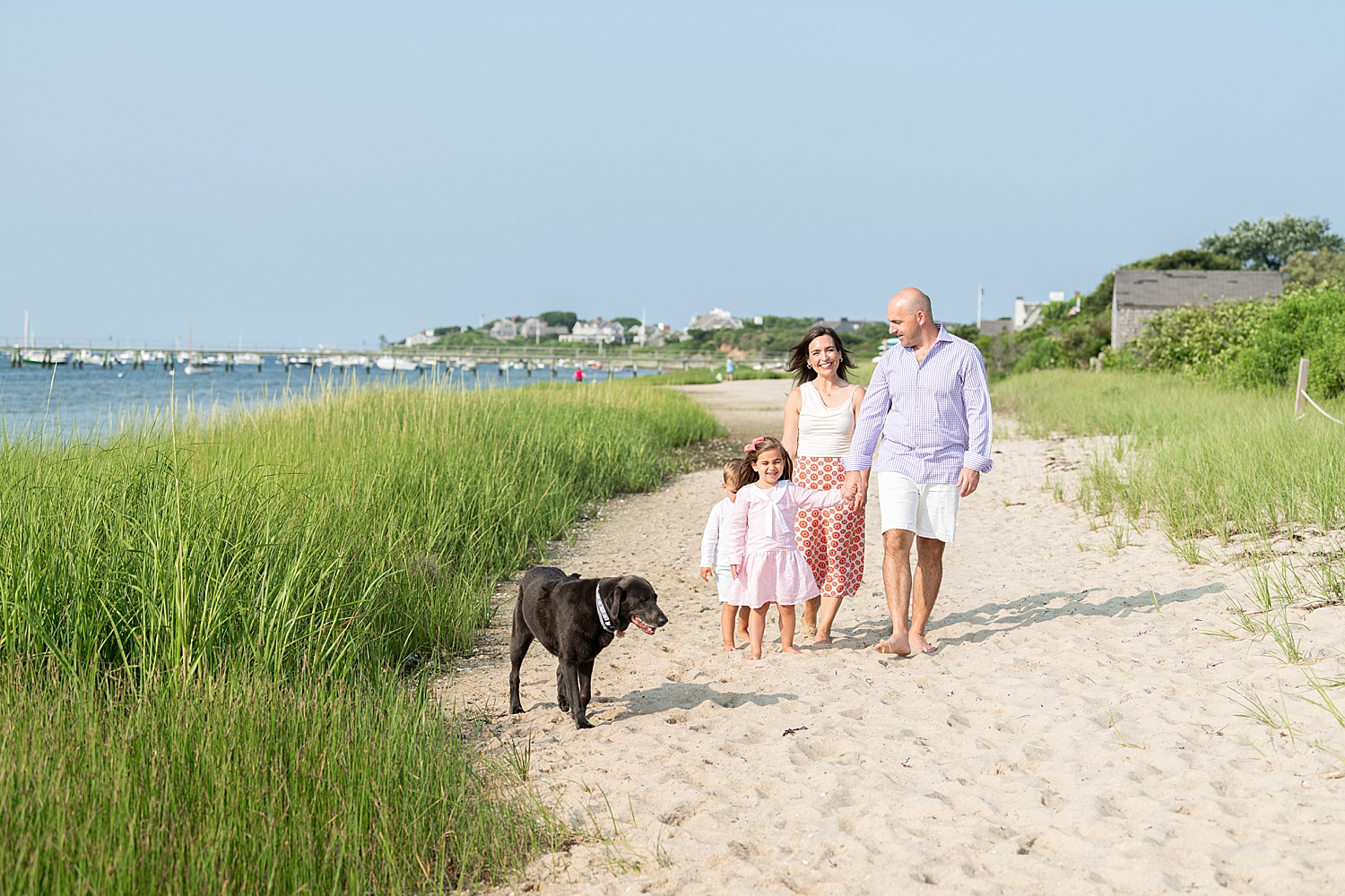 family of 4 walks with their dog on the beach by Rachel Elizabeth Photography