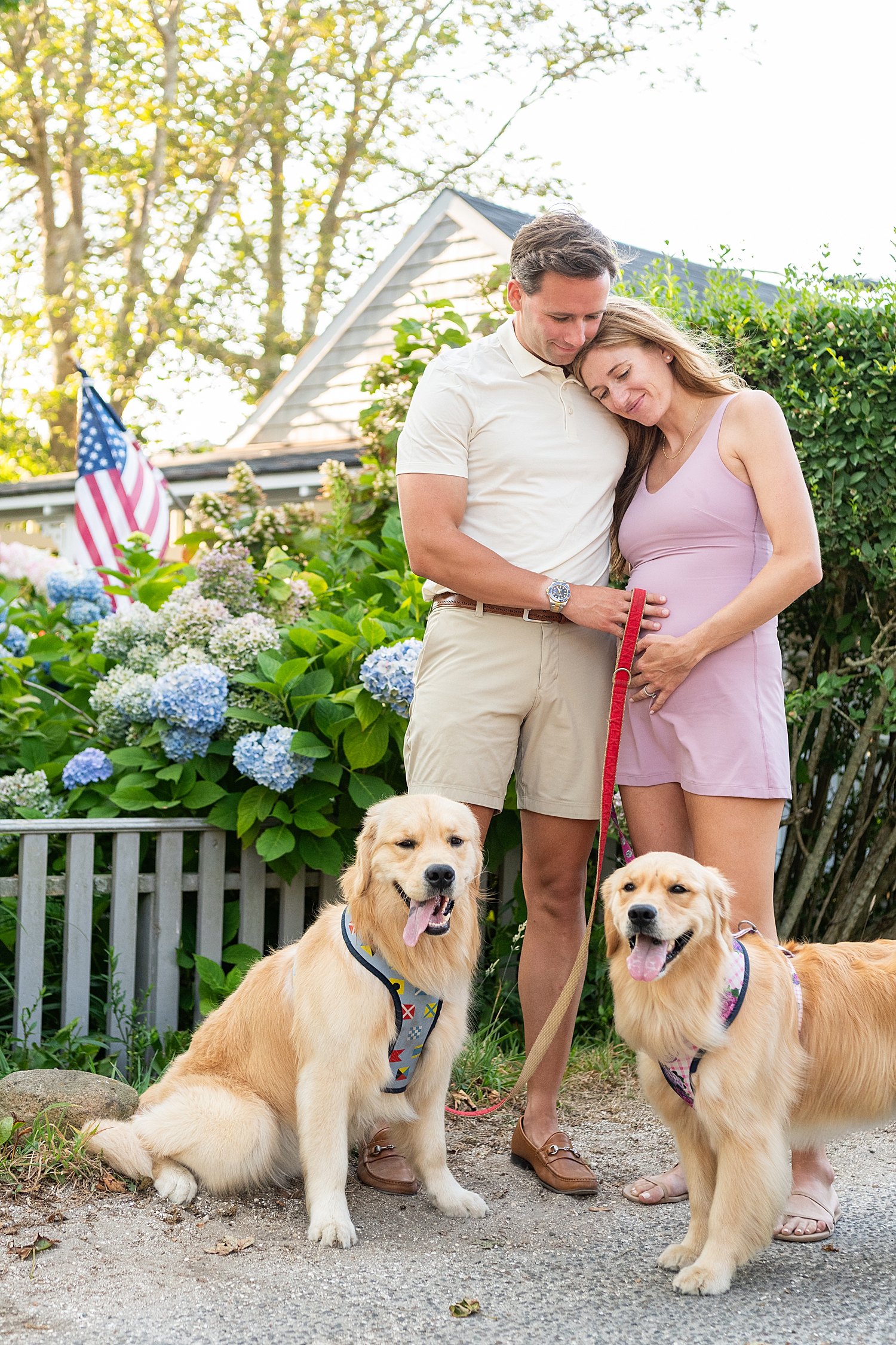 couple stand with their two dogs on sidewalk by Rachel Elizabeth Photography