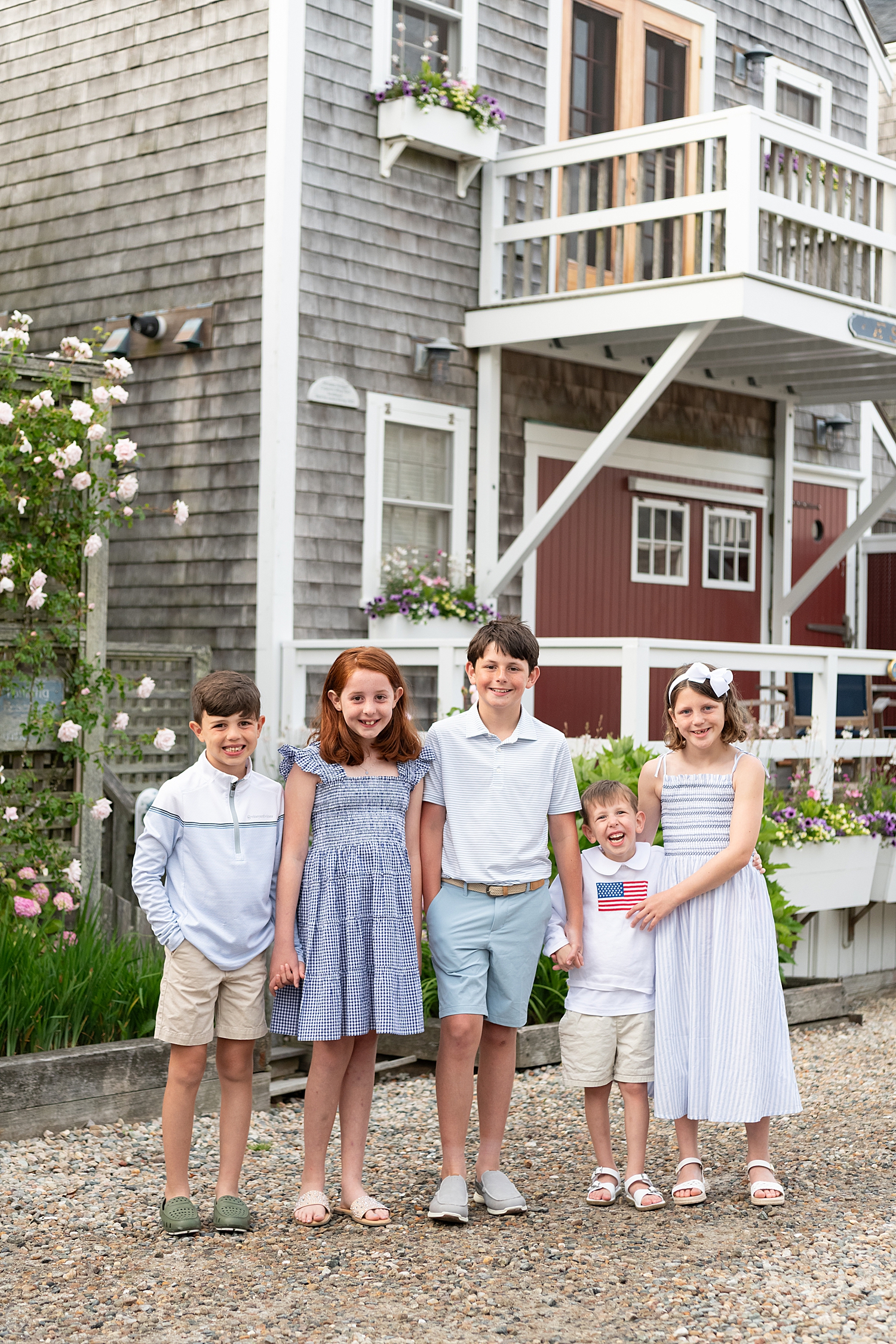 cousins all standing together in front of old building by Nantucket Family Photographer