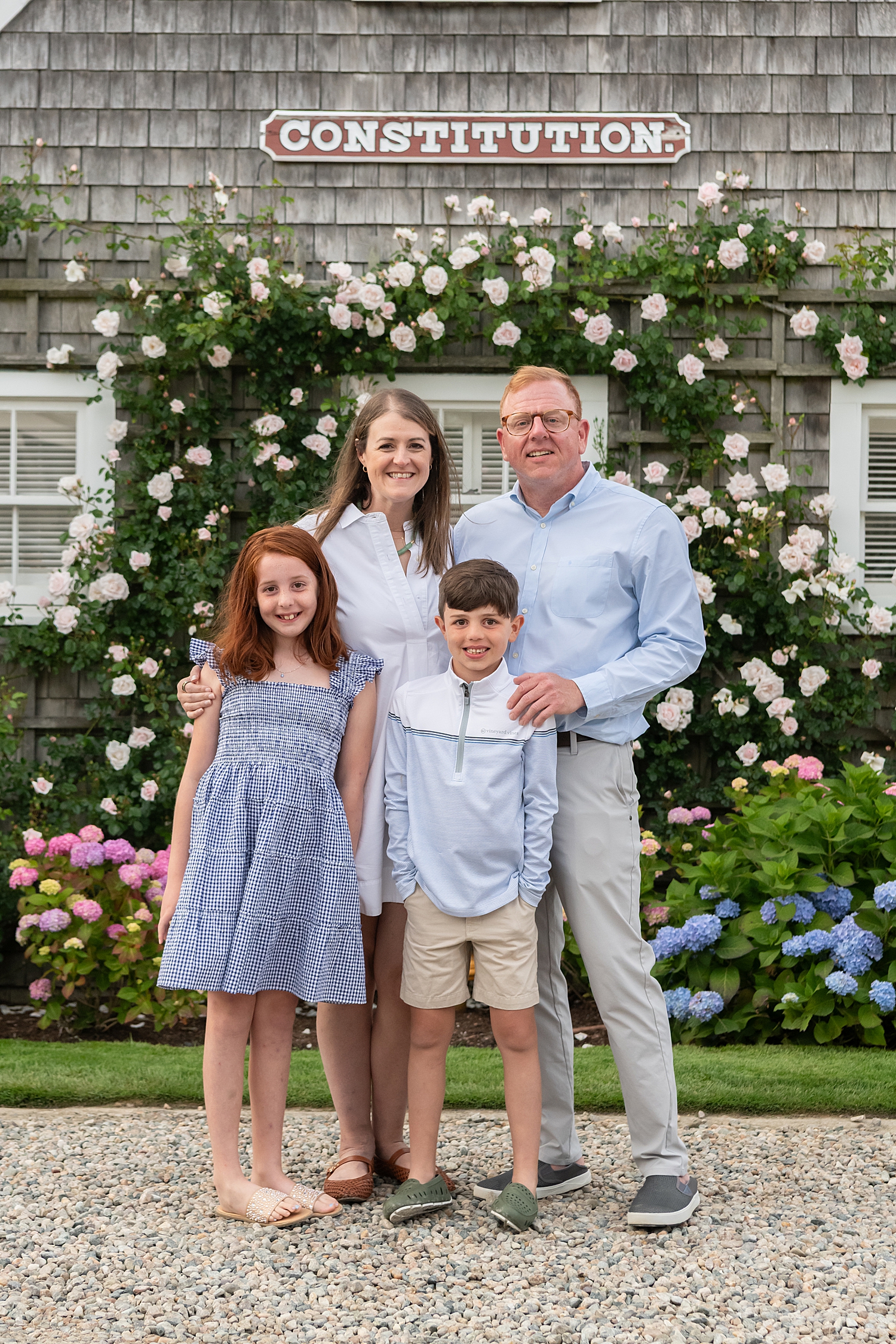parents with their two kids in front of flowers by Nantucket Family Photographer
