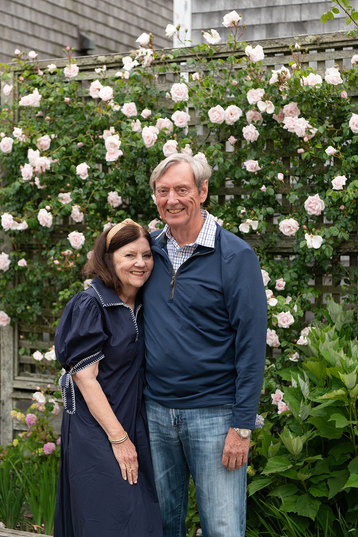 older couple in front of pink rose bushes at Old North Wharf