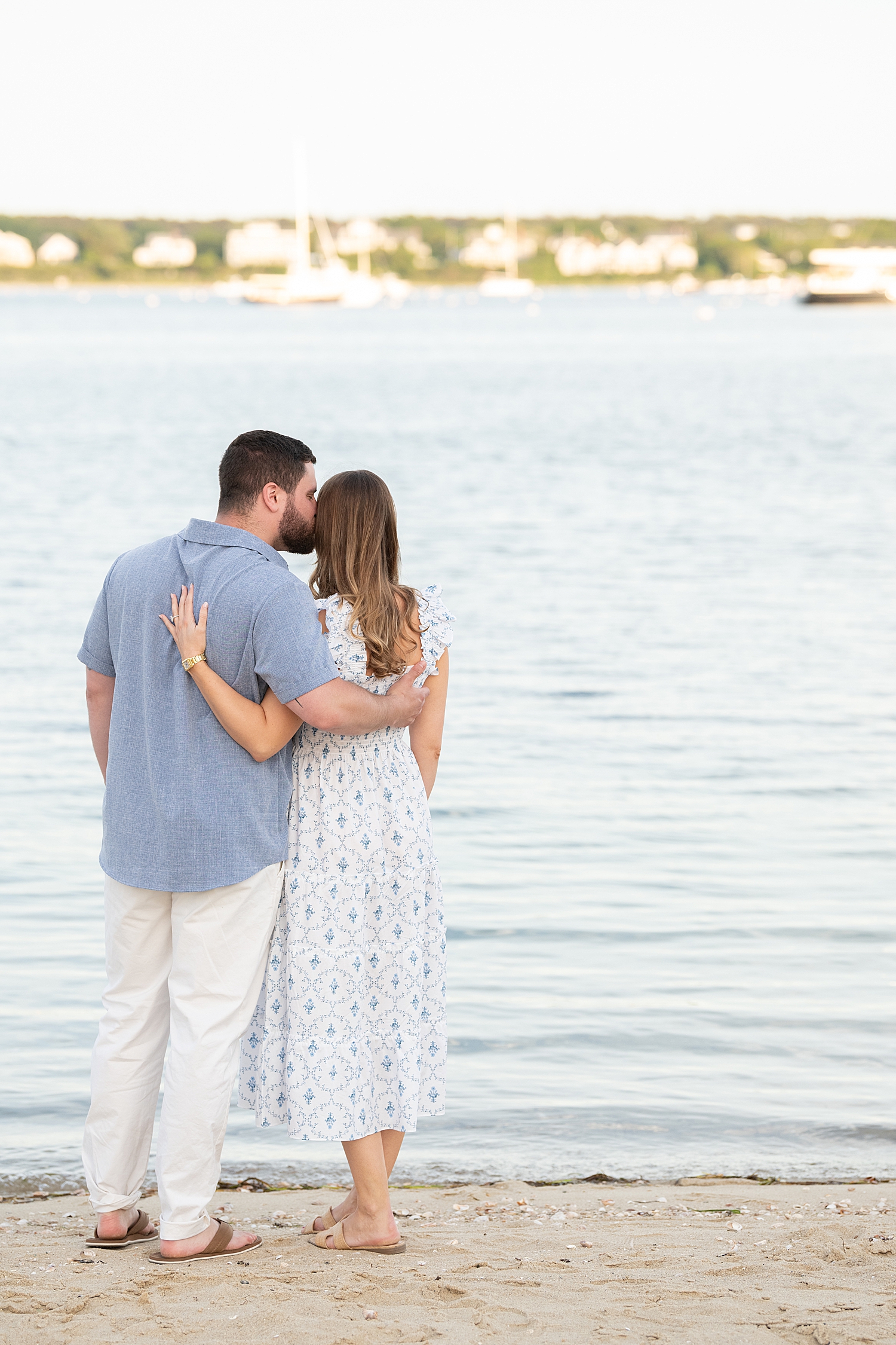 couple stands looking out over the water for Sunset Proposal at Brant Point Lighthouse