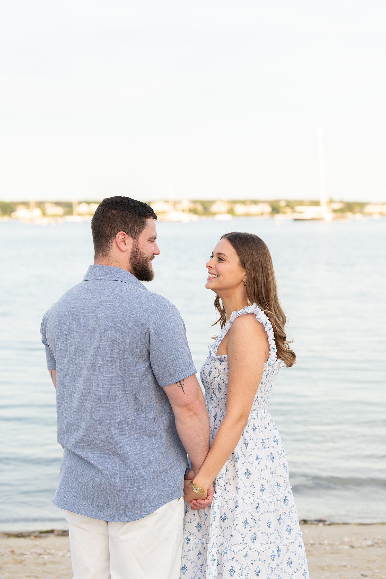 woman gazes at new fiance in front of ocean by Nantucket family photographer