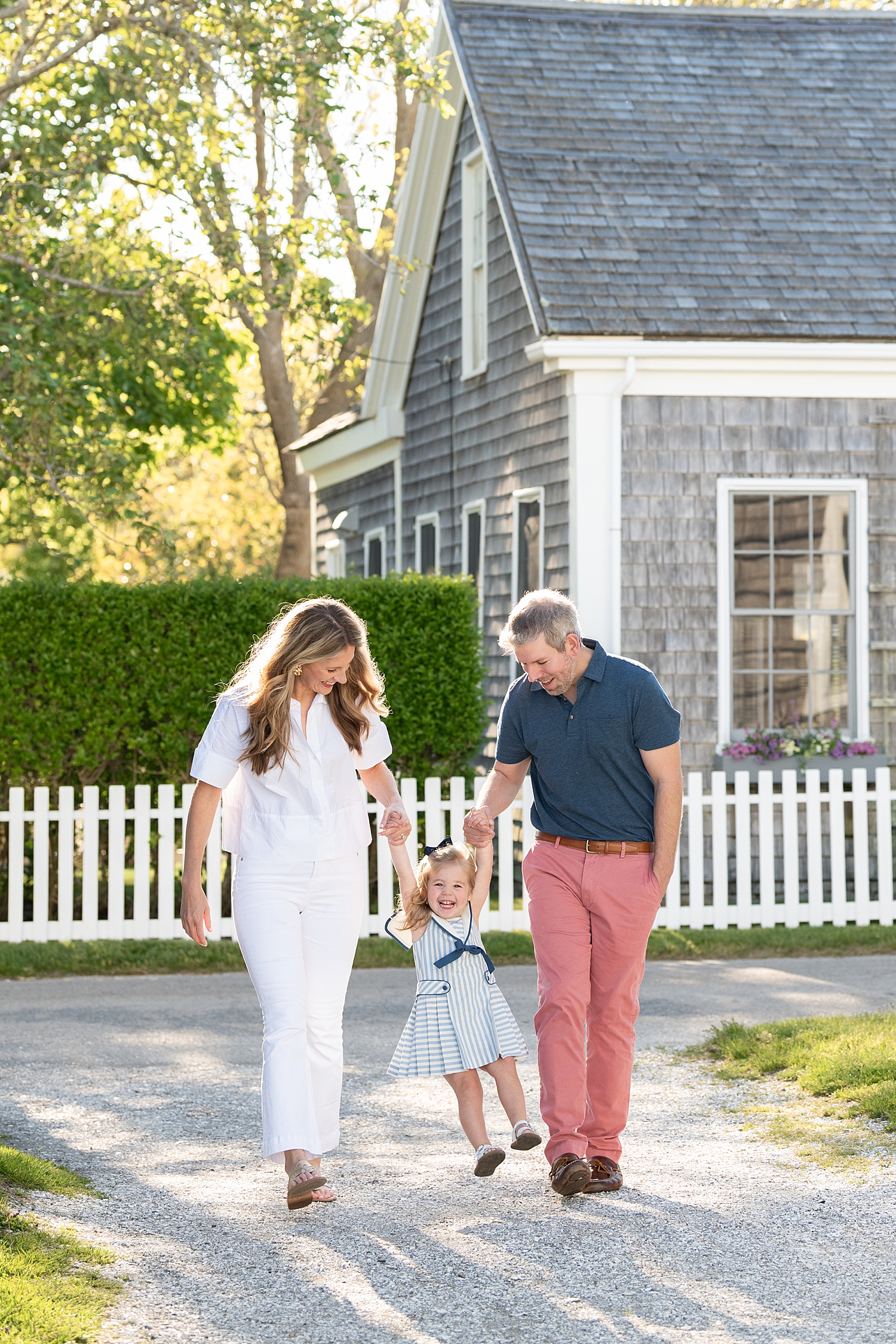 mother and father walk with toddler on sidewalk by Nantucket family photographer