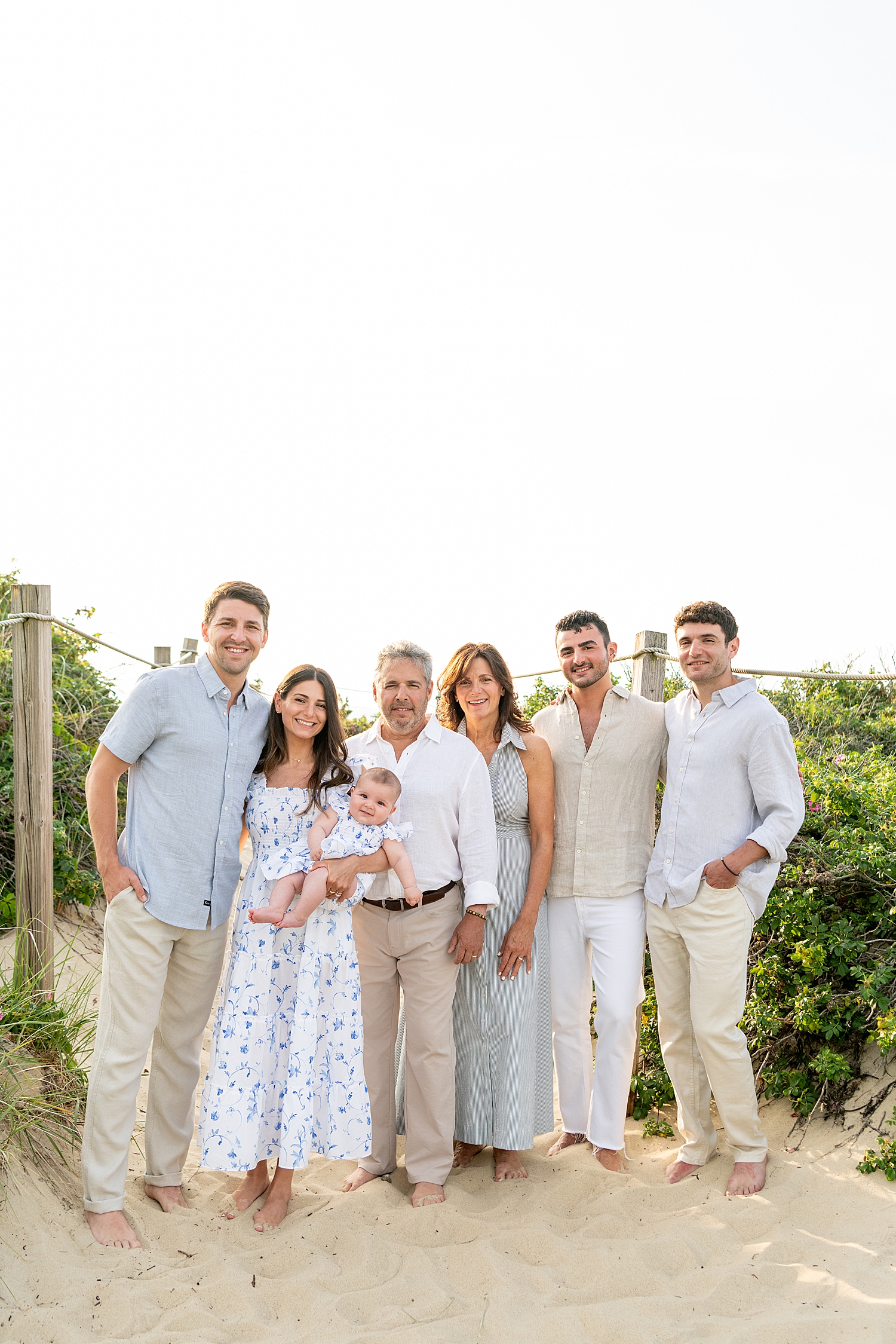 large group stands in sand next to ocean by Nantucket family photographer