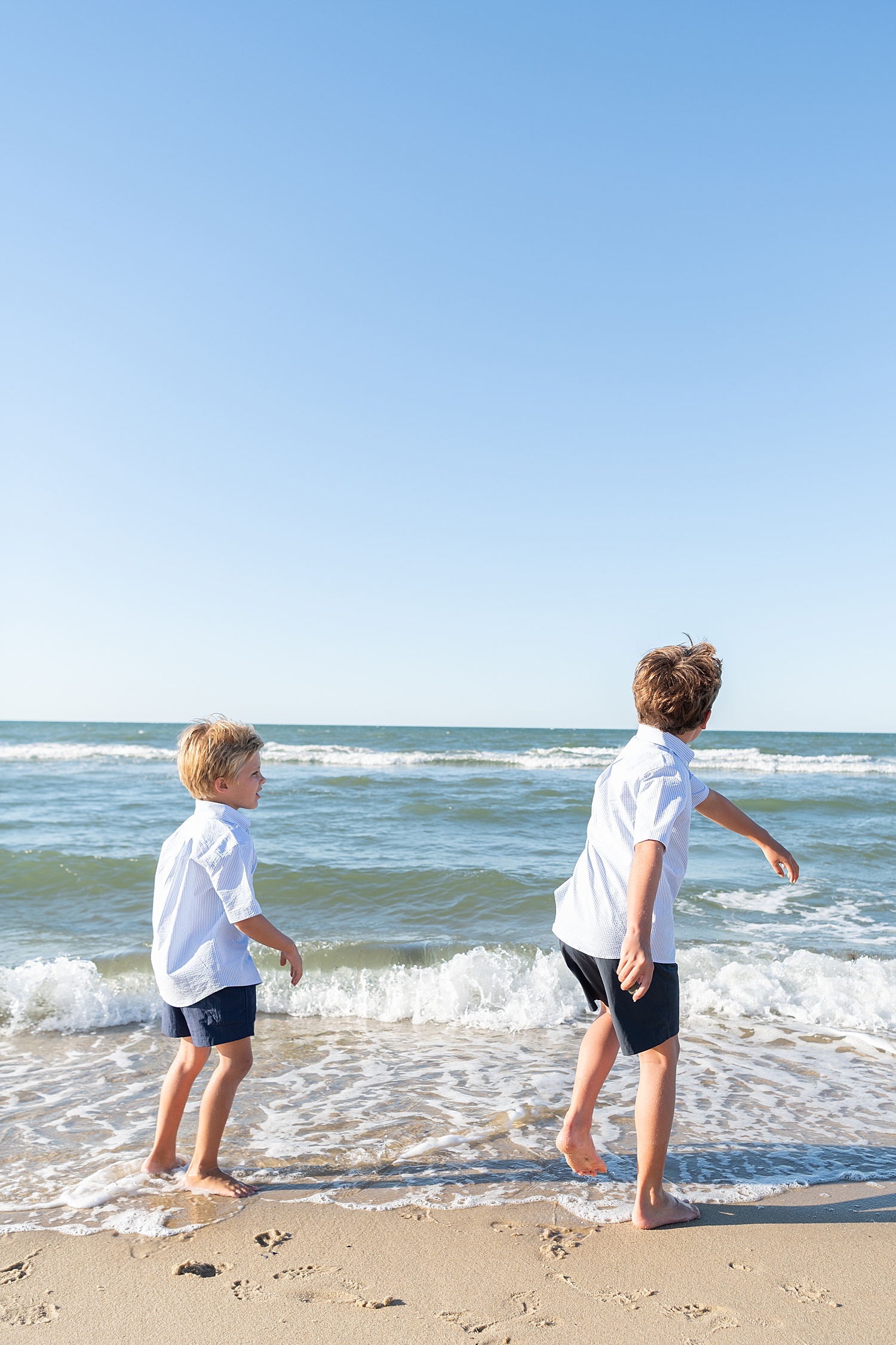 two boys throw rocks in the ocean showing how to personalize your session