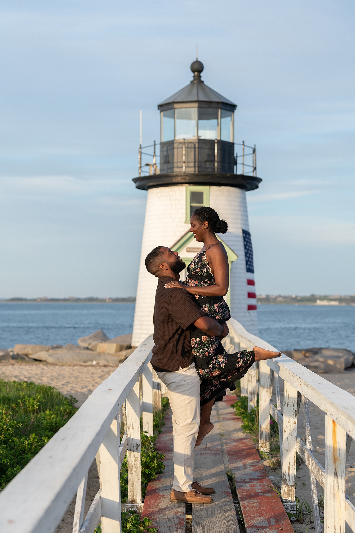 couple kiss in front of a lighthouse by Nantucket portrait photographer