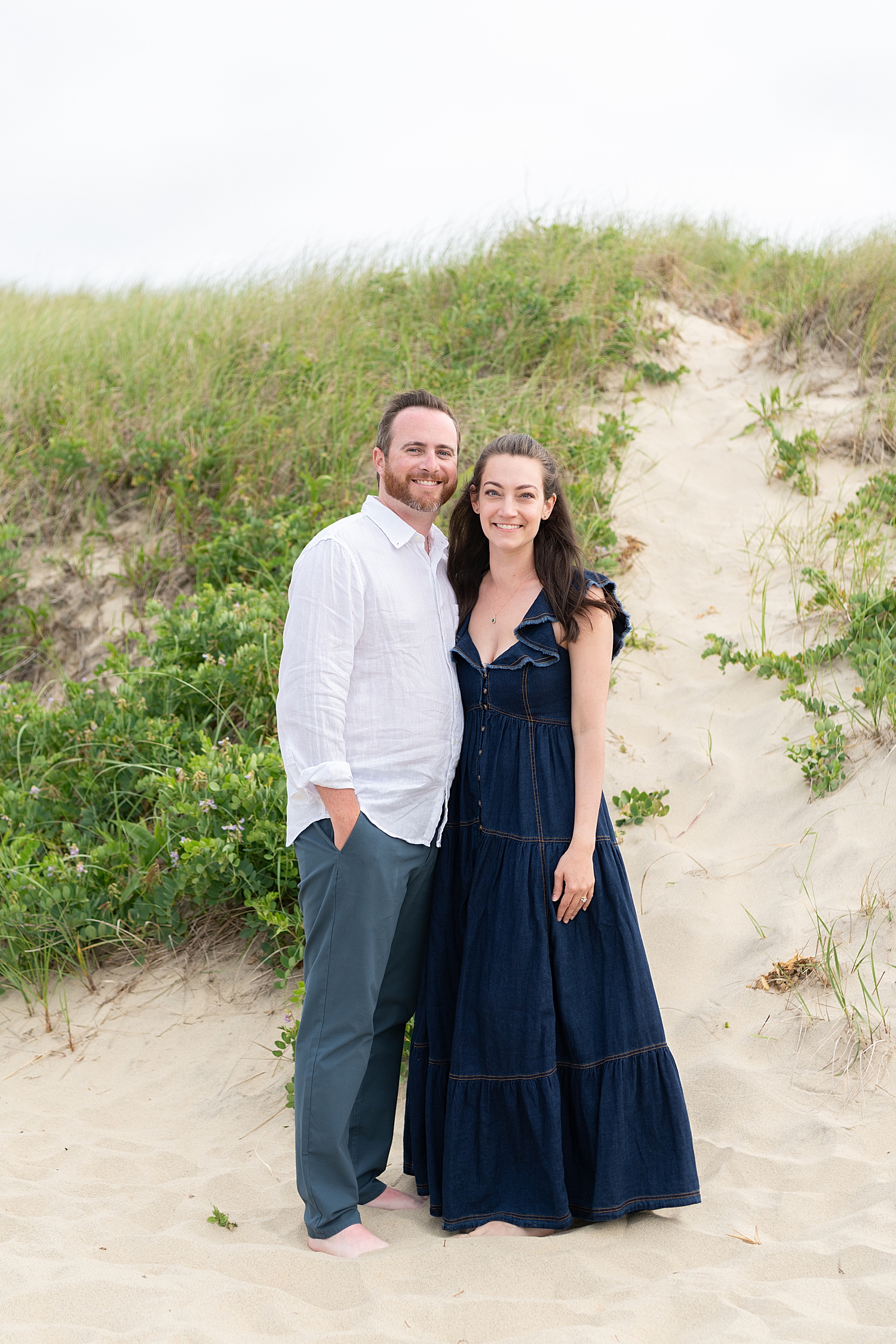 couple stand together next to ocean by Nantucket Family Photographer