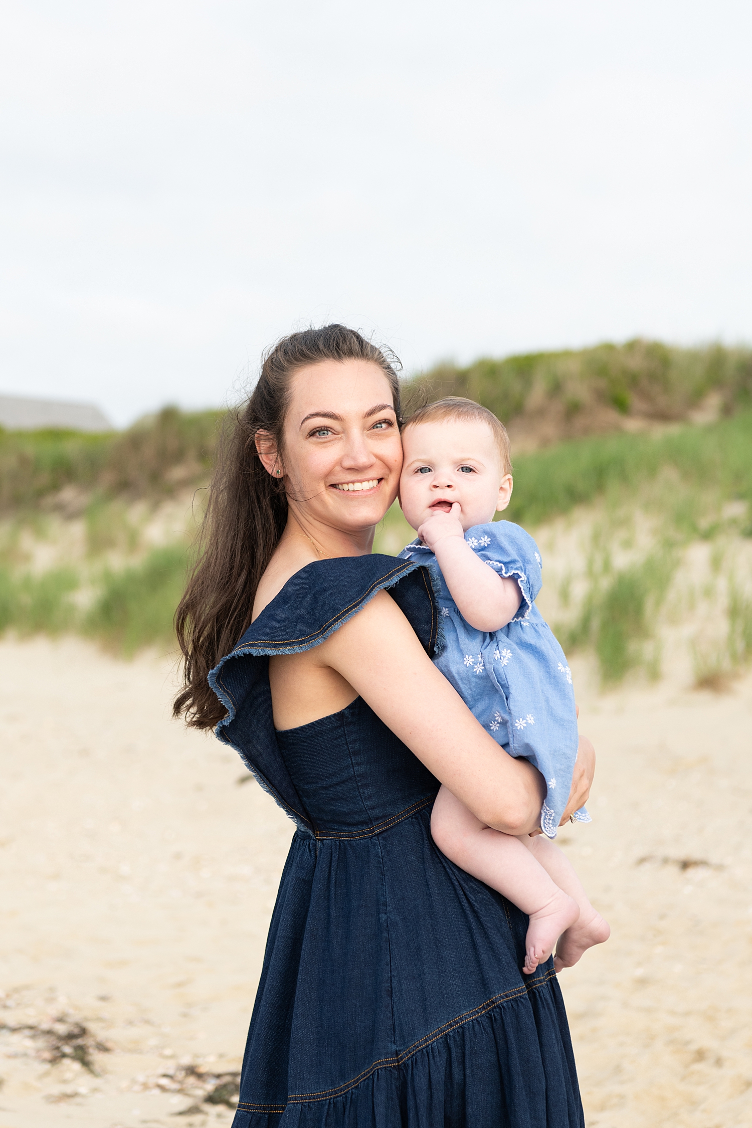 new mom holds her infant by sand dunes by Rachel Elizabeth Photography