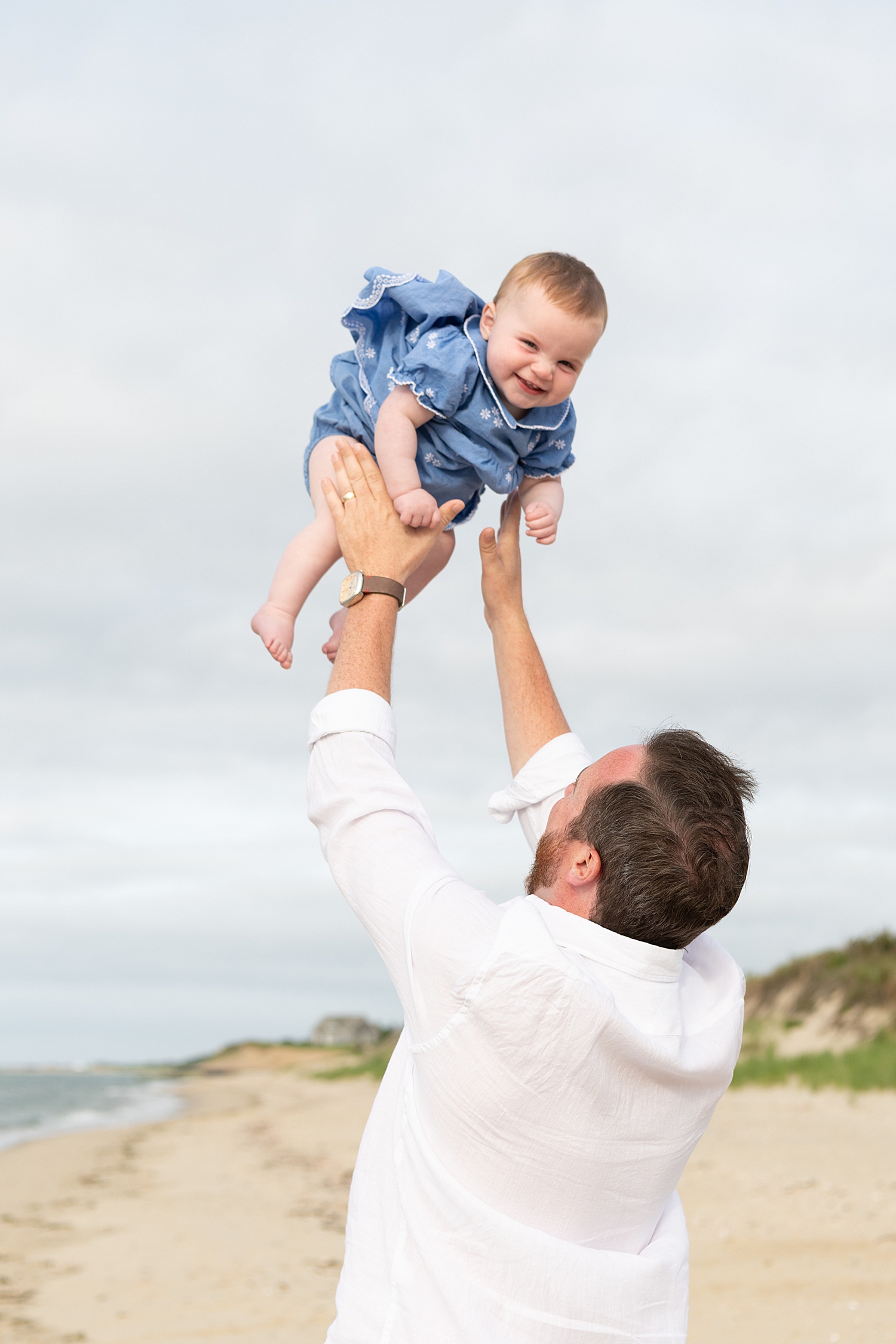 dad throws baby up in the air for Summer session at Washing Pond Beach