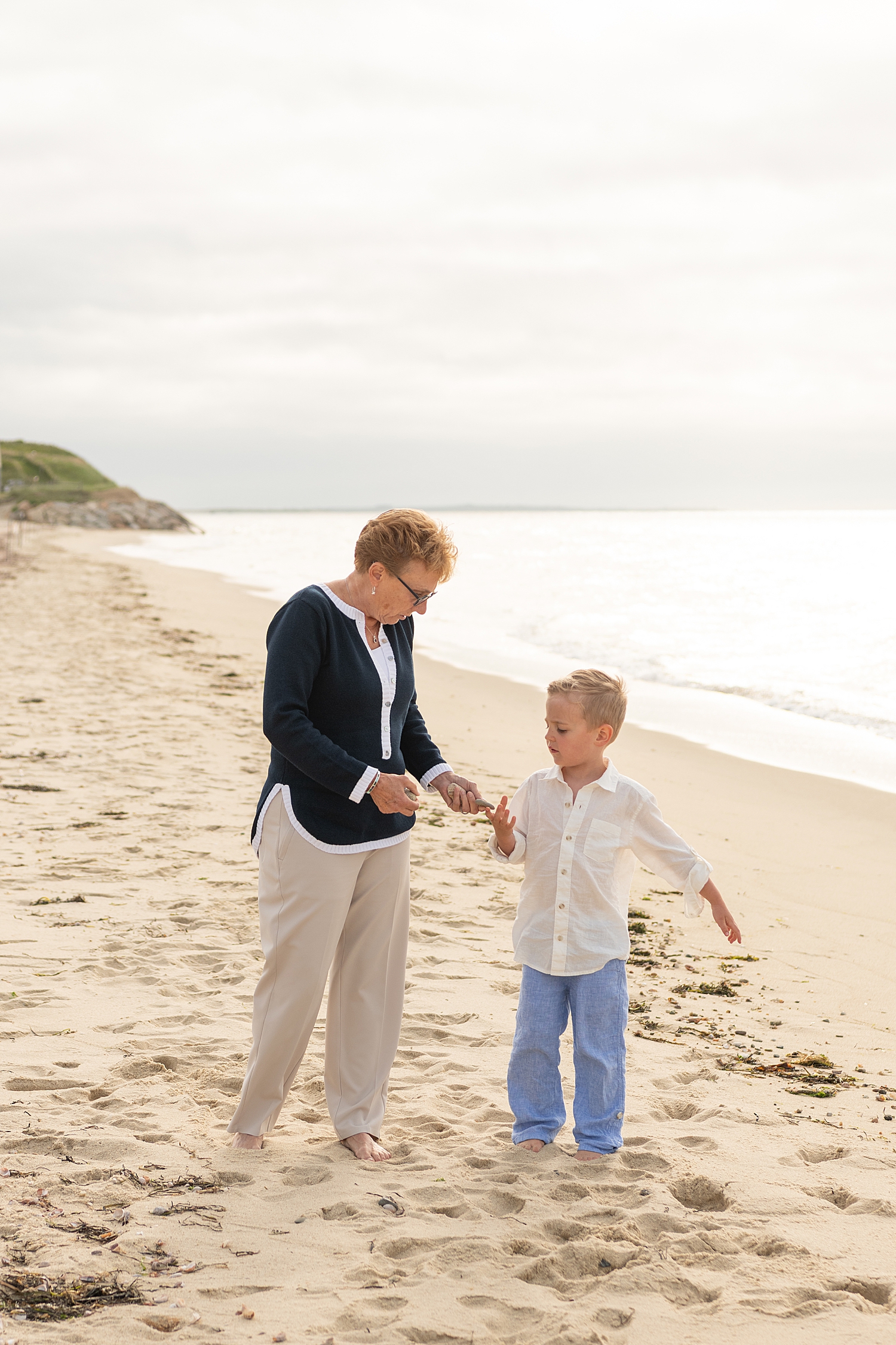 grandmother walks with grandson on the beach 