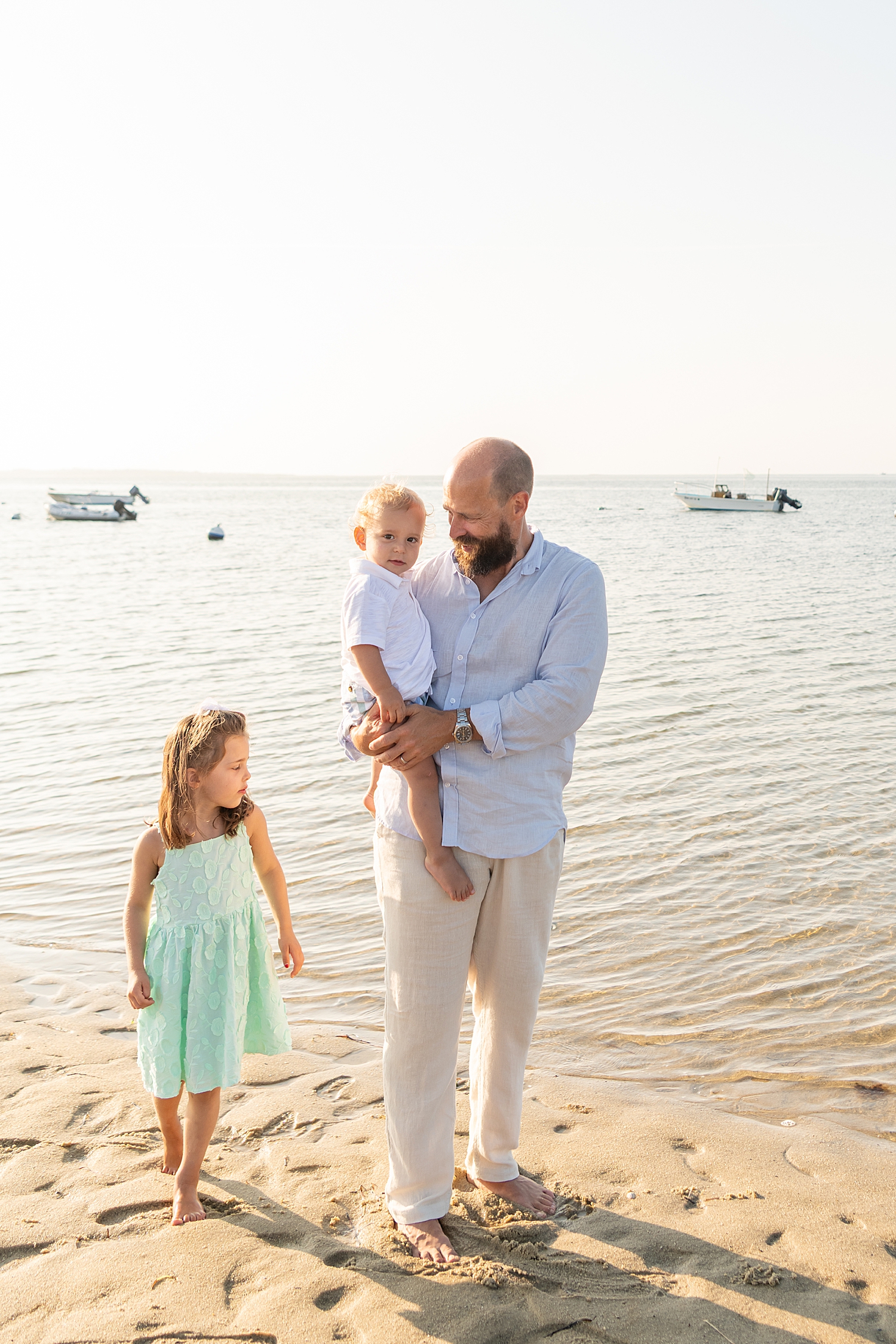 dad holds son and walks with daughter on the shoreline by Rachel Elizabeth Photography