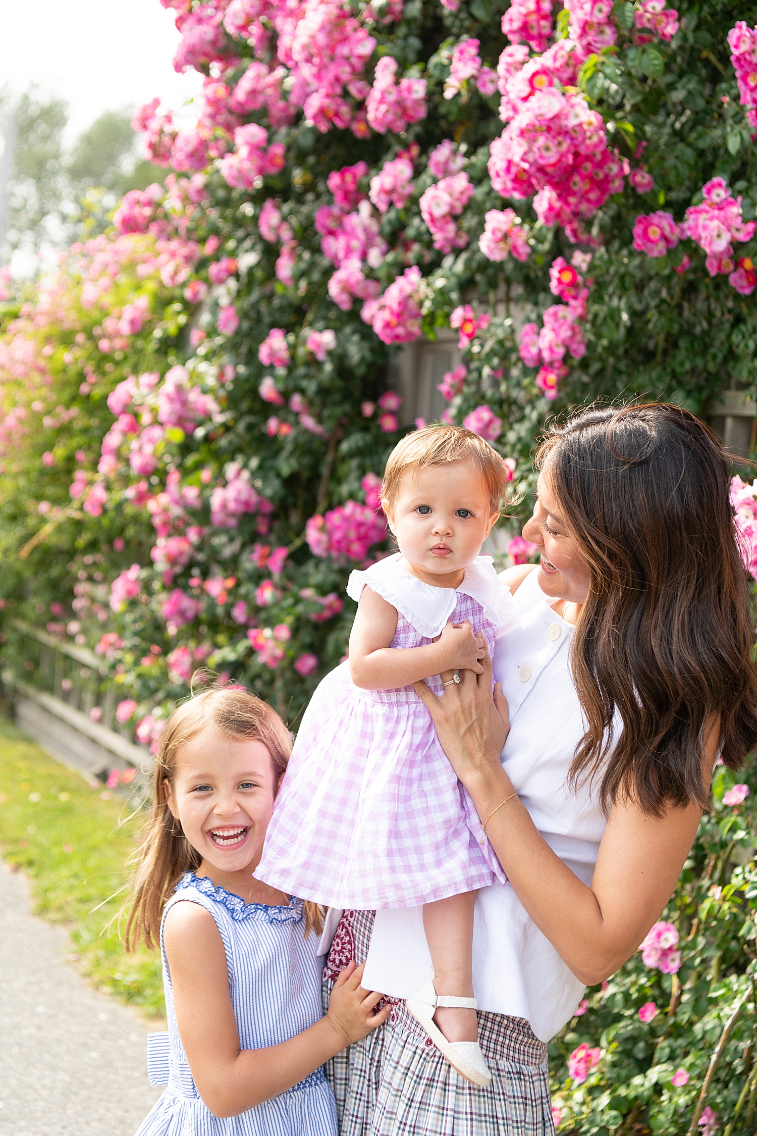 mom plays with her two daughters in front of hydrangeas by Rachel Elizabeth photography