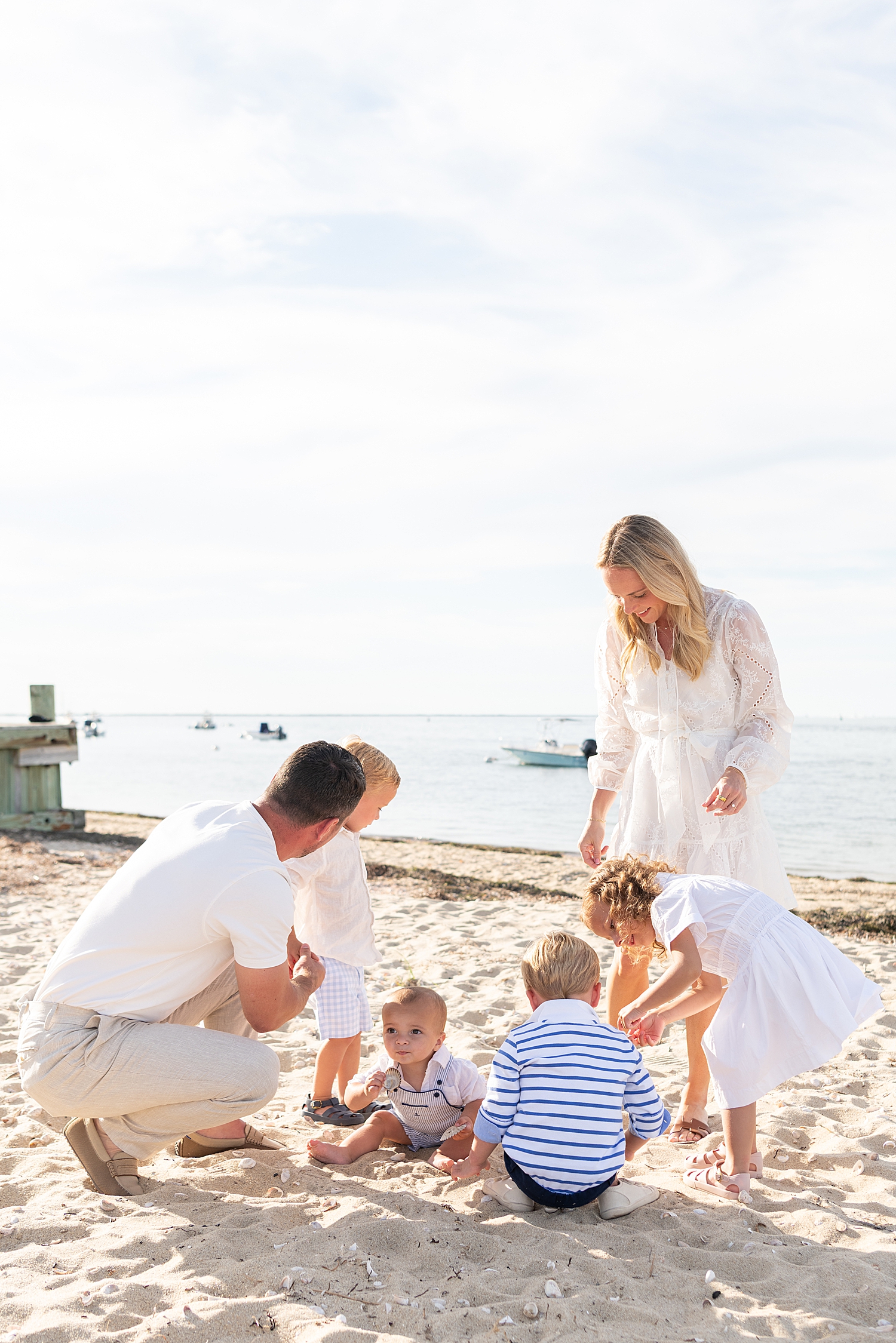 parents play with their kids in the sand on the island by Nantucket family photographer