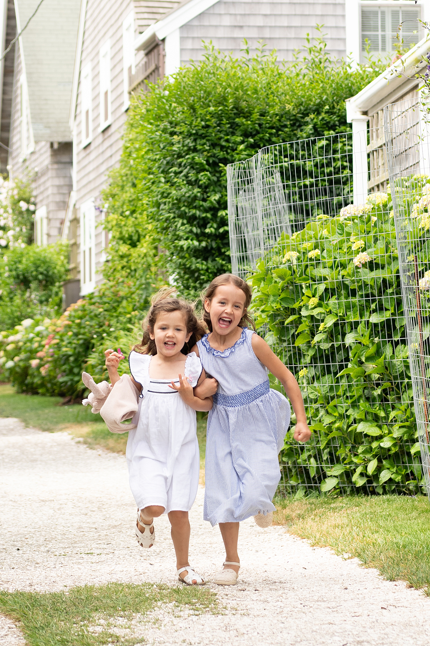 two small girls run down gravel path by Rachel Elizabeth Photography
