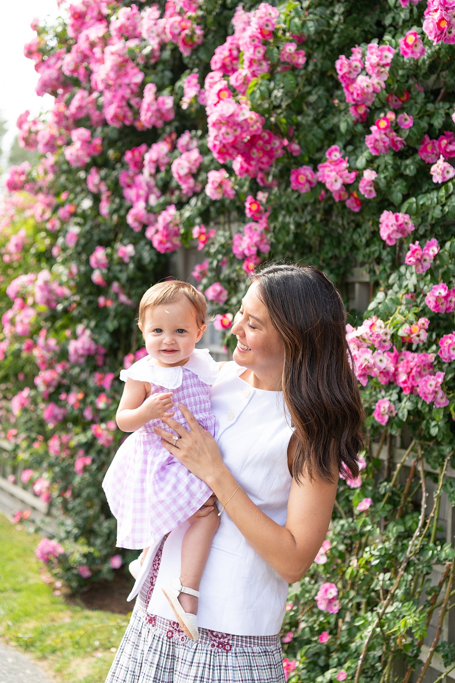 brunette mother holds her baby daughter in front of hydrangeas by Nantucket family photographer
